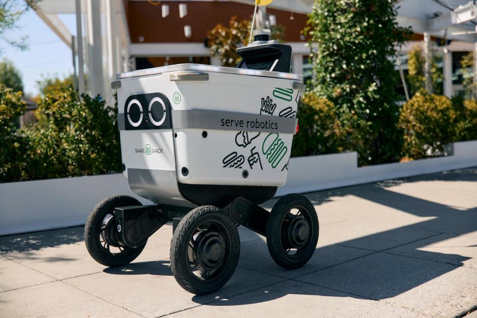 Một robot Serve trên vỉa hè đang giao đơn hàng Shake Shack.