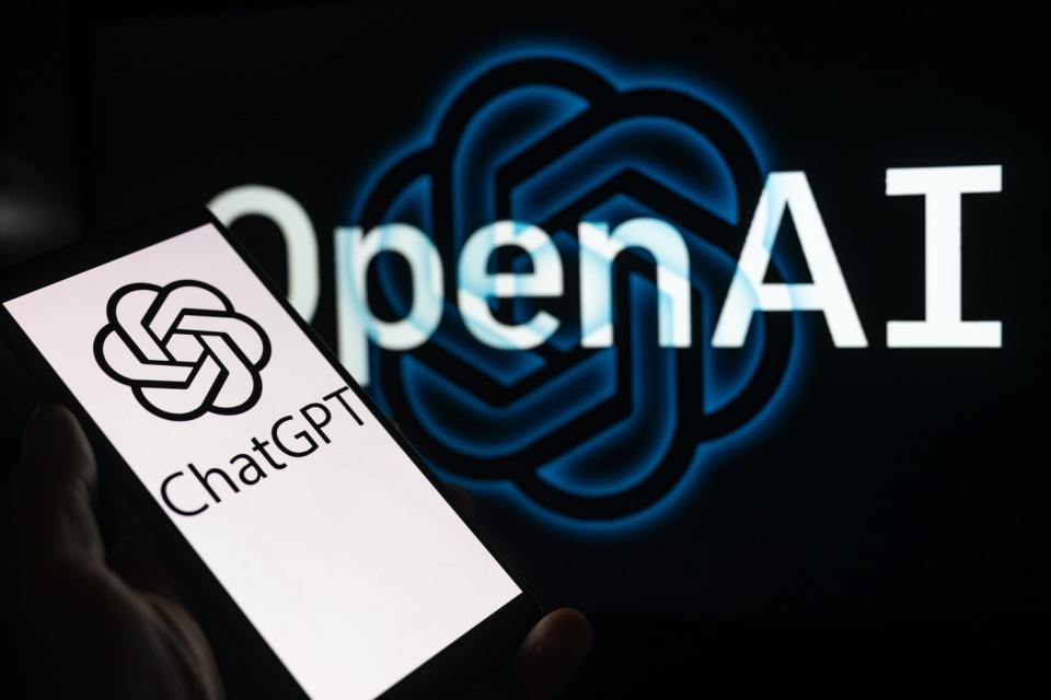 Logo OpenAI và ChatGPT với điện thoại thông minh ở phía trước.